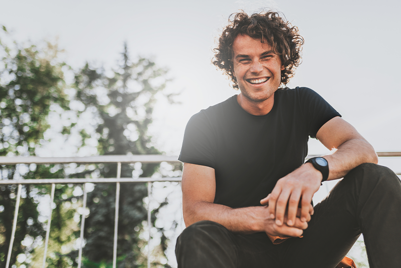 young smiling man outside