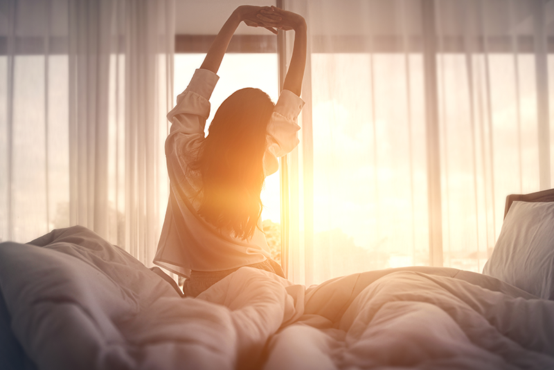 a woman waking up in bed