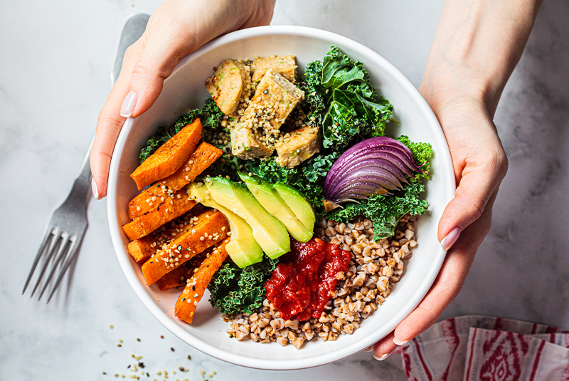 a person holding a bowl of healthy food