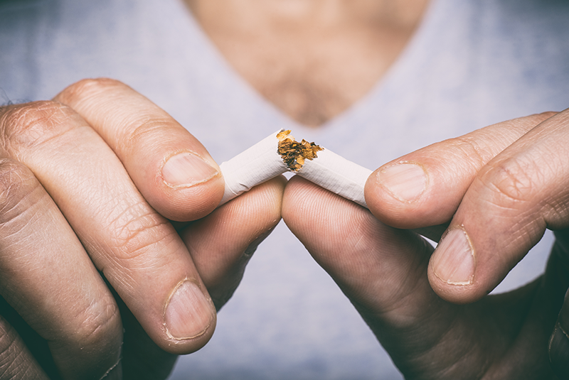 a person breaking a cigarette in half